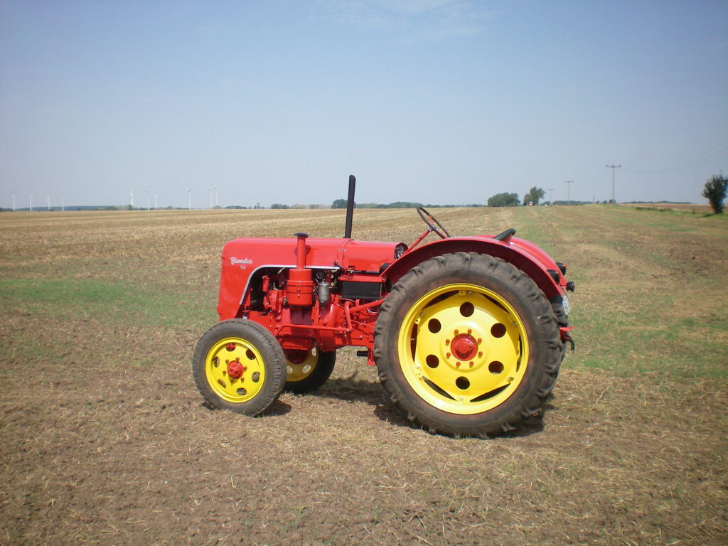 Alter roter Traktor "Famulus RS 14/46 W" von der Seite, steht auf einem Feld